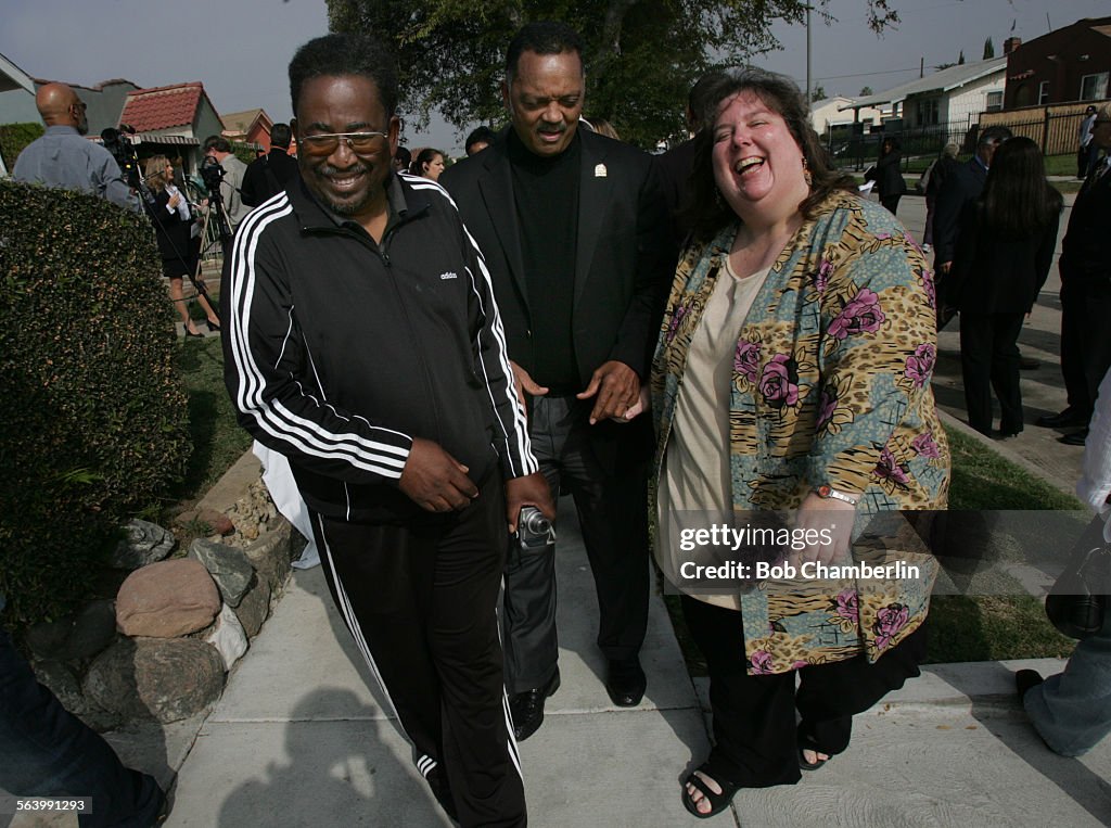 The reverend Jessie Jackson, center, shares a light moment as he takes a walk around the neighborho