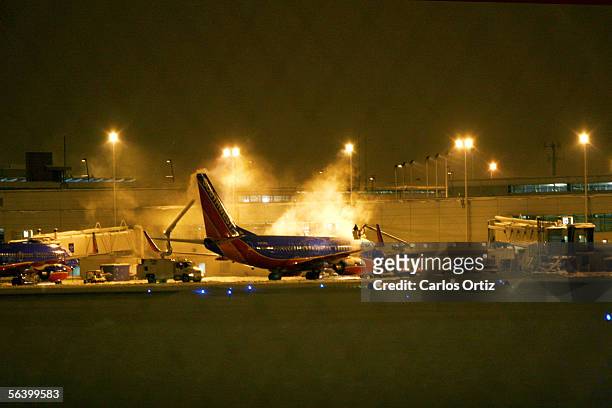 Ground crews de-ice a Southwest Airlines plane at Midway Airport in the early morning hours December 9, 2005 in Chicago, Illinois. Earlier in the...
