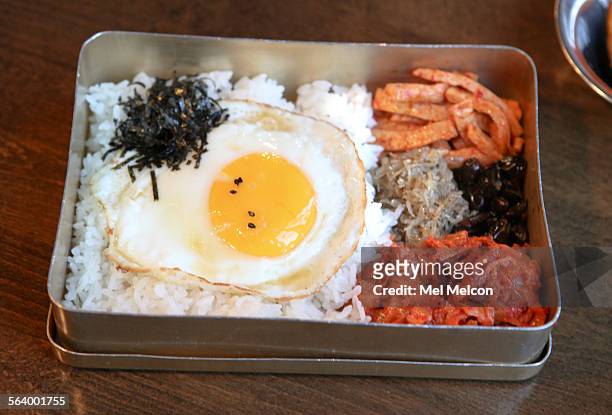 Dosirak, consisting of kimchi, a sunrise egg, black bean sweetened dried anchovies and steamed rice is served in a kid's lunchbox that is shaken...