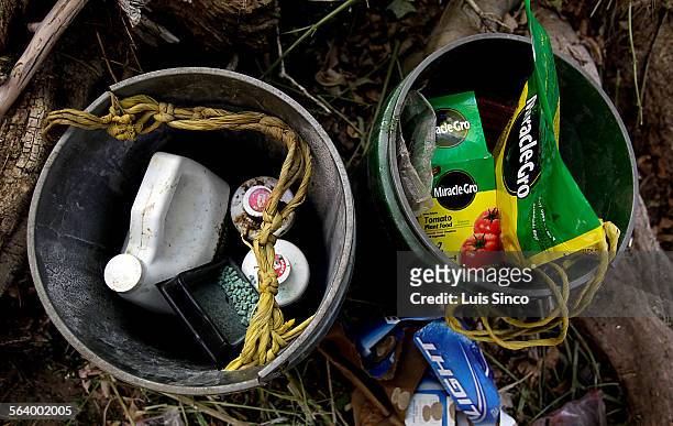 Buckets containing fertilizer, pesticides and rat poison sit in an encampment used by marijuana growers in an illegal operation in the Sierra Nevada...