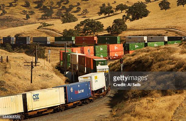 Freight train slowly climbs eastbound heading into Tehachapi Pass crossing the Tehachapi Mountains near Caliente in Kern County, California on the...