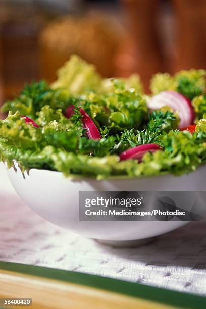 bowl of salad with slices of red onion sitting on a paper towel, close-up, part of - red onion imagens e fotografias de stock
