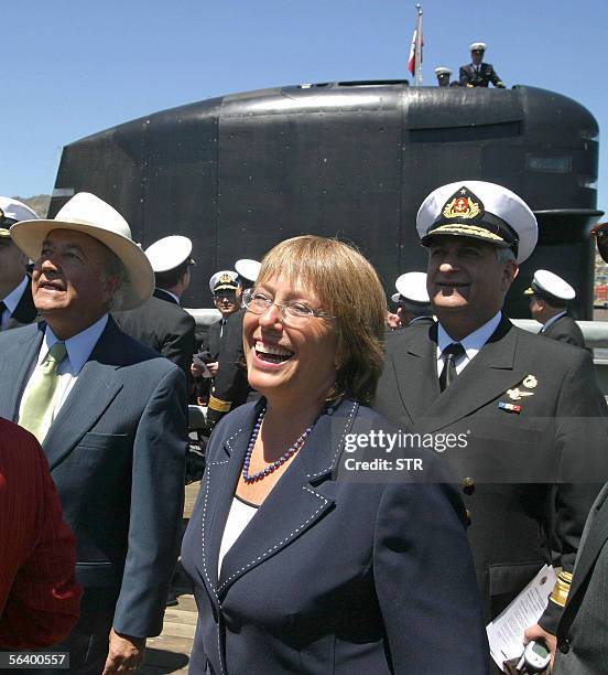 Chilean presidential hopeful and former Defence Minister Michelle Bachelet shares a joke with officials during the launching of Chile's O'Higgins...