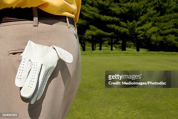 golf glove hanging out of man's pocket - back pocket photos et images de collection