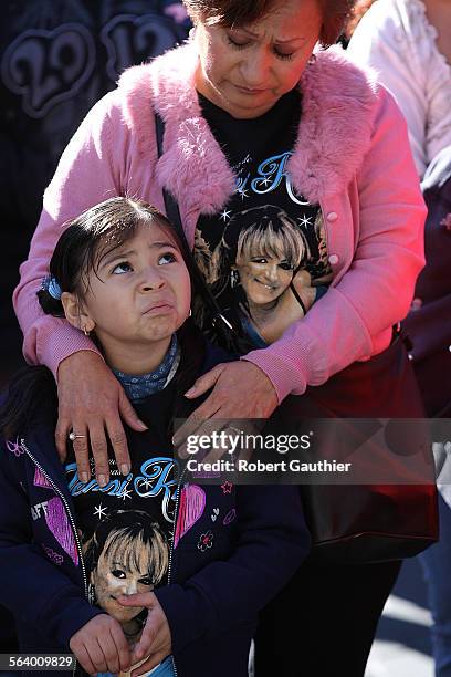 Betsy Hernandez is comforted by her grandmother, Soledad Hernandez as they watch a broadcast of Jenni Rivera's memorial service at Universal Citywalk.