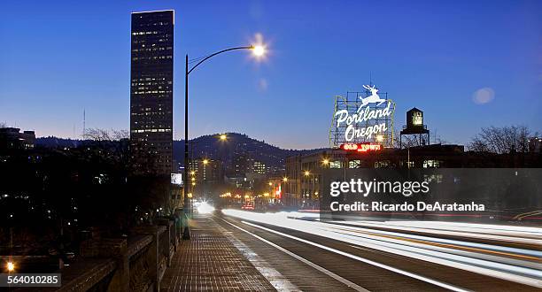 Vehicle lights create light streaks over the Burnside Bridge with Old Town Portland Oregon sign on the back at dusk, January 20, 2013.;