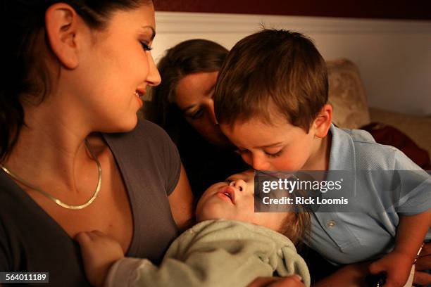 Tucson, Az.  Celeste Lawrence holds her oneyearold daughter Cadence while Elena Zurheide's son Robbie, also oneyearold, gives Cadence a kiss on...