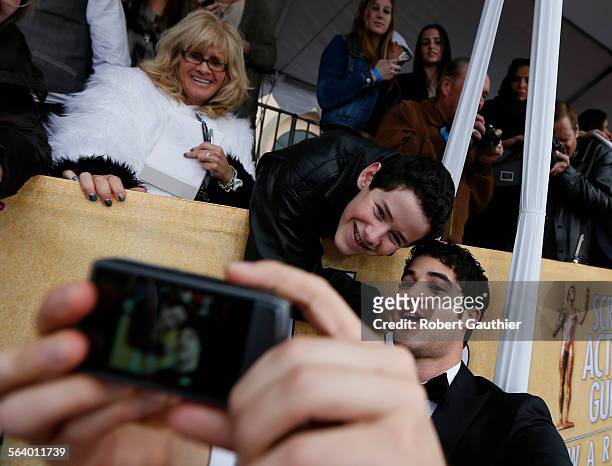 January 27, 2013 Darren Criss, bottom right, gives fan Coby Hillborne of Woodland Hills, an autograph photo at the 19th Annual Screen Actors Guild...
