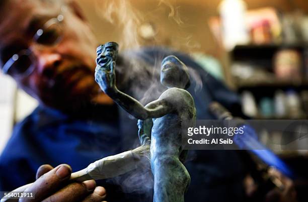 Skilled craftsman Ricardo Godinez works on the distinctive blue-green patina achieved through chemical oxidation, a natural process that is sped up...