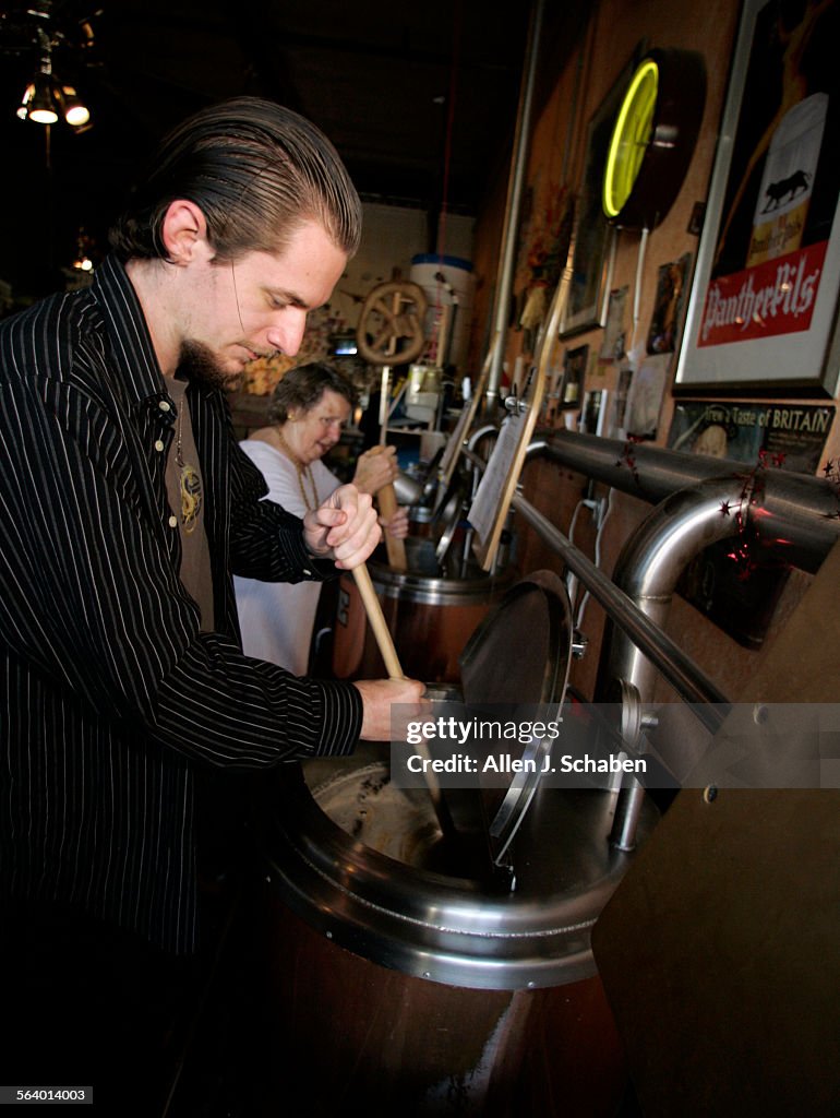 Josh Edey (CQ) 23, left, and Beverly Wells, make Surf City Red Ale in the brew kettle at Brewbakers