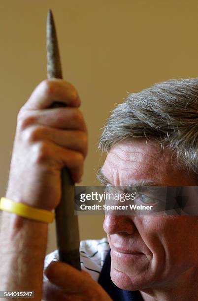 Bruce Kennedy at home in Santa Barbara, holding one of his javelin's with which he set a personal best score. Story about athlete who was part of...