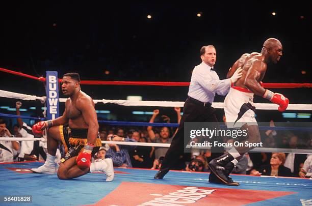 Evander Holyfield is guided away by the referee after knocking opponent Ray Mercer to his knees during a fight on May 20, 1995 in Atlantic City, New...