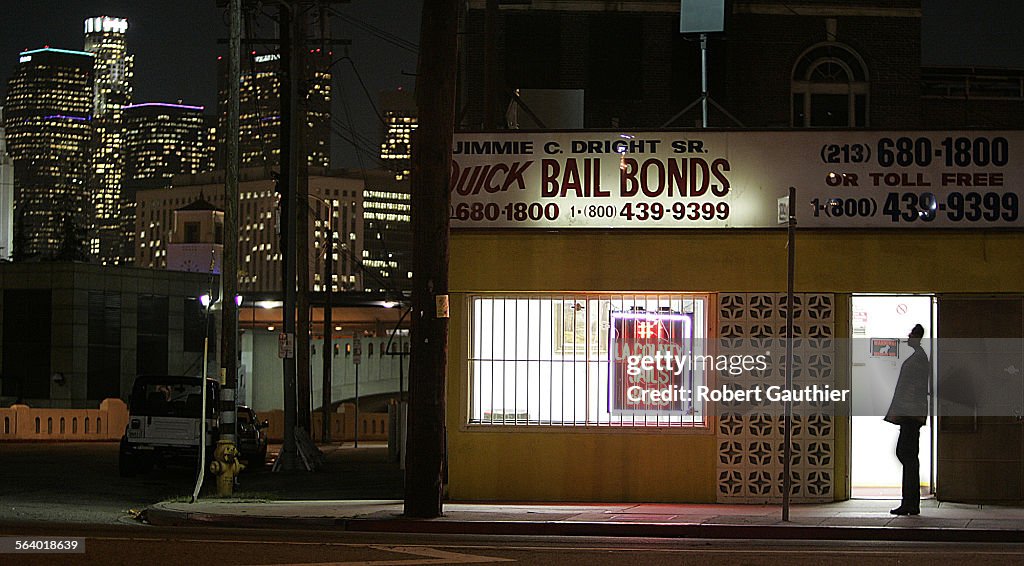 The lights of downtown Los Angeles shine behind the Quick Bail Bonds building on Vignes Street acro