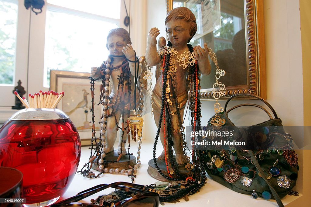 Left to righta match striker, italian cherubs, and an antik batik evening bag sit atop a chest of