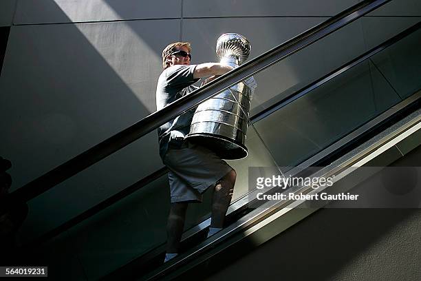Mike Bolt, keeper of the cup for the Hockey Hall of Fame in Toronto, Canada, totes the Stanley Cup up an escalator at Hollywood and Higland after...
