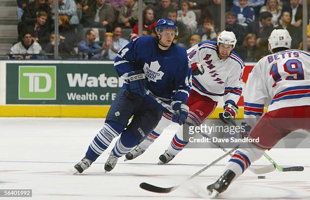 Defenseman Staffan Kronwall of the Toronto Maple Leafs skates with the puck as Blair Betts and Jason Ward of the New York Rangers defend during their...