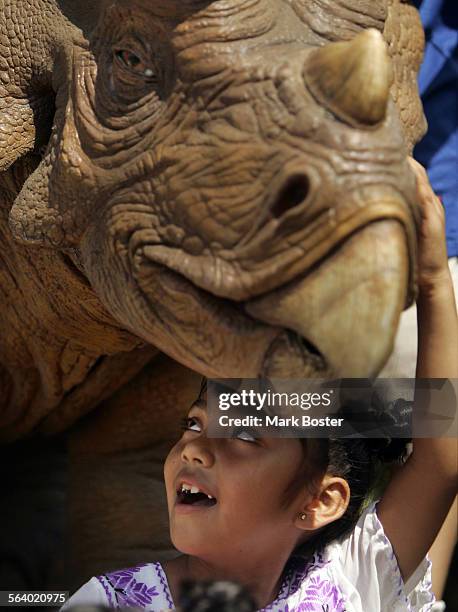 Rosemary Cornelio from Santa Ana plays with an interactive triceratops at the Discovery Scince Center in Santa Ana. Next to the triceratops is the...