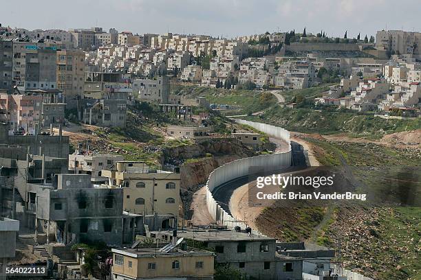 The serpentine path of a concrete section of the Israeli security barrier divides the Palestinian town of Anata, left, and the Israeli town of Pisgat...