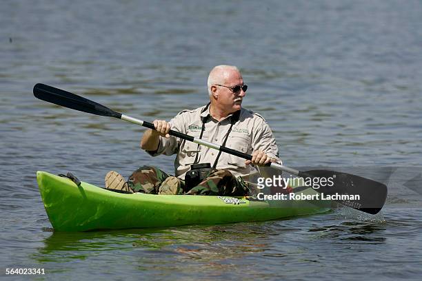 Tim Williams, "Dean of Gator Wrestling" and Director of Media Production at Gatorland in Orlando, Florida uses a kayak as he searches for the...