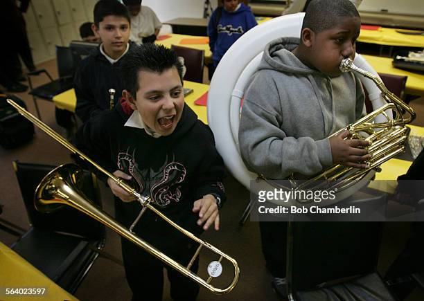 Jorge Ruiz, 12 exults over his new trombone as Rufus Lee III tries out his new Susaphone without the top funnel as youngsters in the Roosevelt Middle...