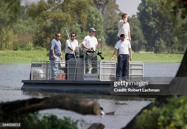 Park officials and alligater catchers from Gatorworld in Orlando, Florida use use a boat as they search for the alligator at Machado Lake in Ken...