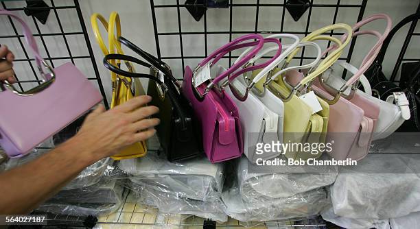 Under cover officer takes purses off wracks after Los Angeles Police Department officers raided "Joi Fashion" clothing accessory store at 1131 A Los...