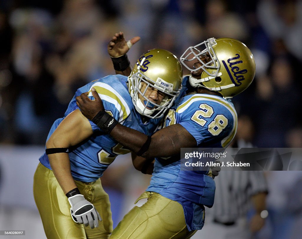 UCLA tailback Chris Markey (28), right, celebrates wide receiver Marcus Everett's third quarter tou