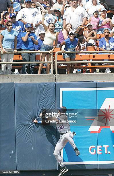 Fans cheer as an eighthinning triple by Dodgers second baseman Antonio Perez bounces off the wall and under the glove of New York Mets centerfielder...