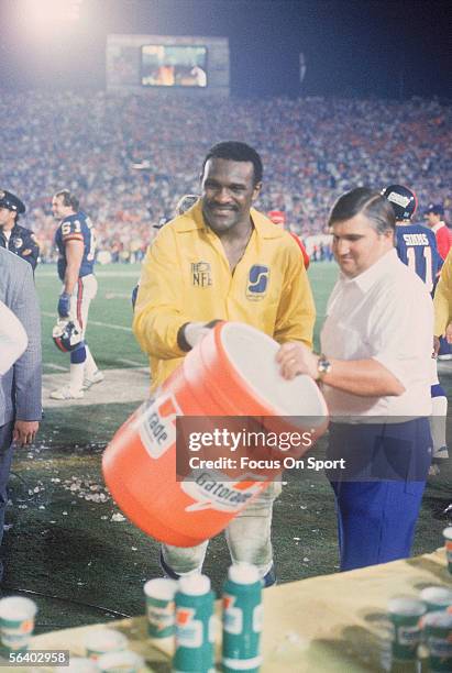 Linebacker Harry Carson of the New York Giants smiles after splashing a bucket of Gatorade over Head coach Bill Parcells after defeating the Denver...