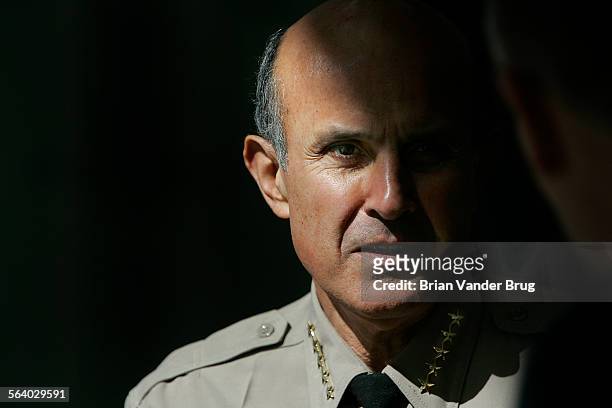 Sheriff Lee Baca waits in the shadows for a press conference to begin following a roundtable meeting on airport and port security with Congresswoman...