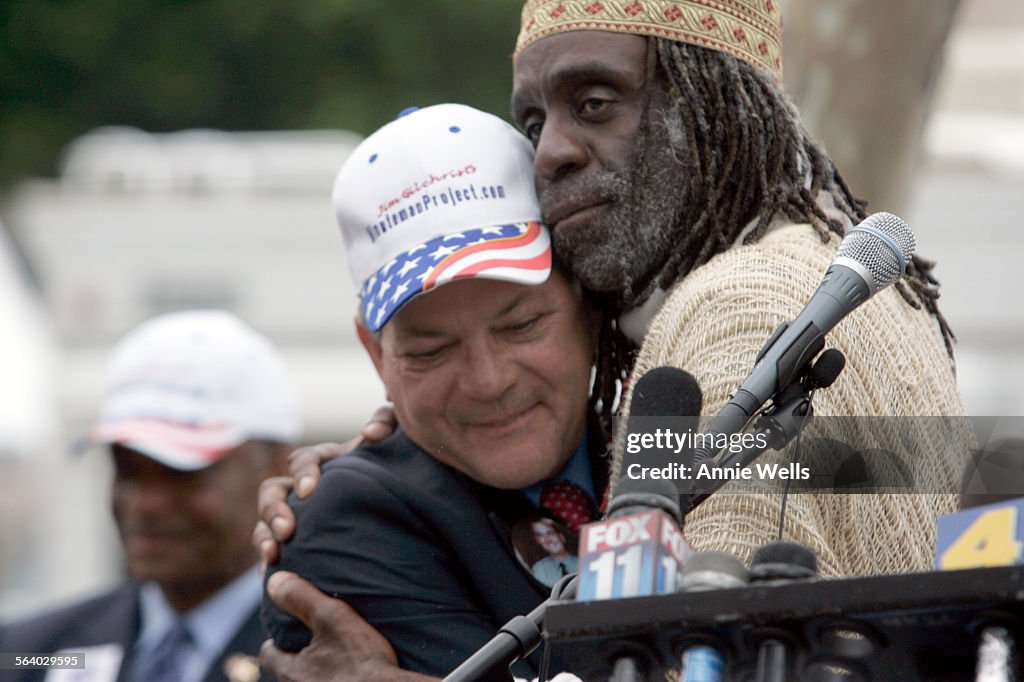 Homeless activist Ted Hayes hugs Minuteman founder Jim Gilchrist while the two were at the podium t