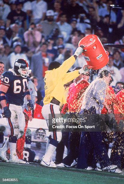 Linebacker Harry Carson of the New York Giants splashes a bucket of Gatorade over Head coach Bill Parcells after defeating the Denver Broncos during...