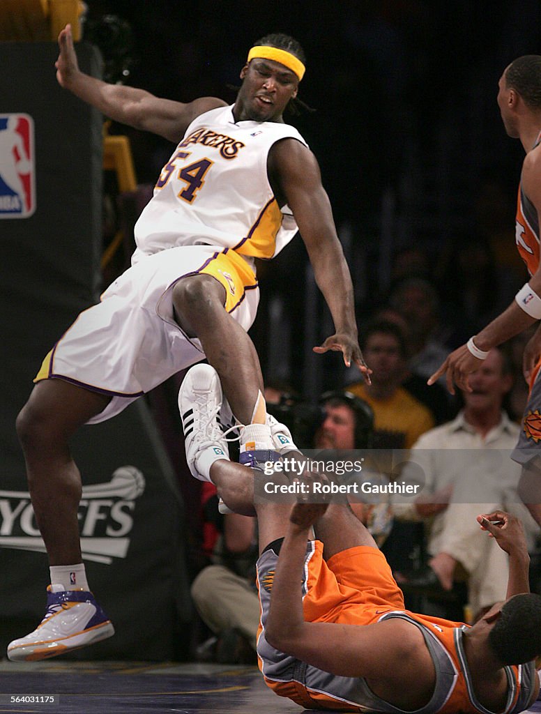 Los Angeles Lakers center Kwame Brown stumbles to the floor after colliding with Phoenix Suns cente