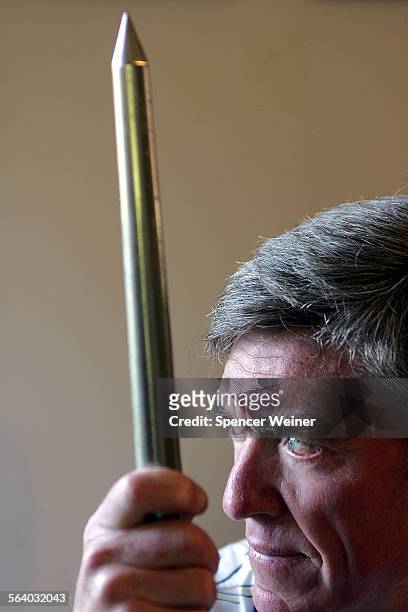 Bruce Kennedy at his home in Santa Barbara, holding one of his javelin's with which he set a personal best score. Story about athlete who was part of...