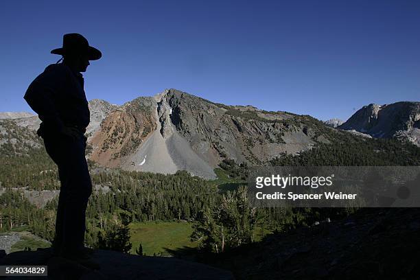 Eight miles into the wilderness along the John Muir Trail, Ed Sauls of Laguna Beach watches as the sun begins to set over secluded Purple Lake. Sauls...
