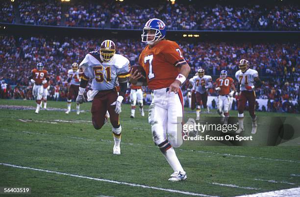 John Elway of the Denver Broncos carries the ball near the sidelines during Super Bowl XXII against the Washington Redskins on January 31, 1988 in...