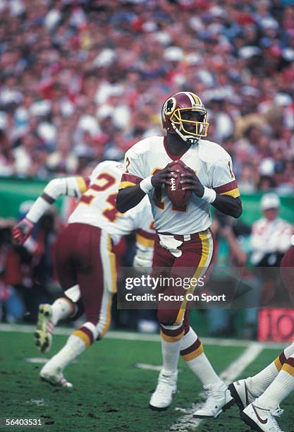 Quarterback Doug Williams steps back and looks for a receiver during Super Bowl XXII against the Denver Broncos on January 31, 1988 in San Diego,...