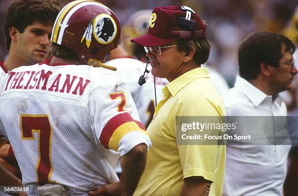 Joe Theismann of the Washington Redskins talks to head coach Joe Gibbs during Super Bowl XVII against the Miami Dolphins at the Rose Bowl on January...