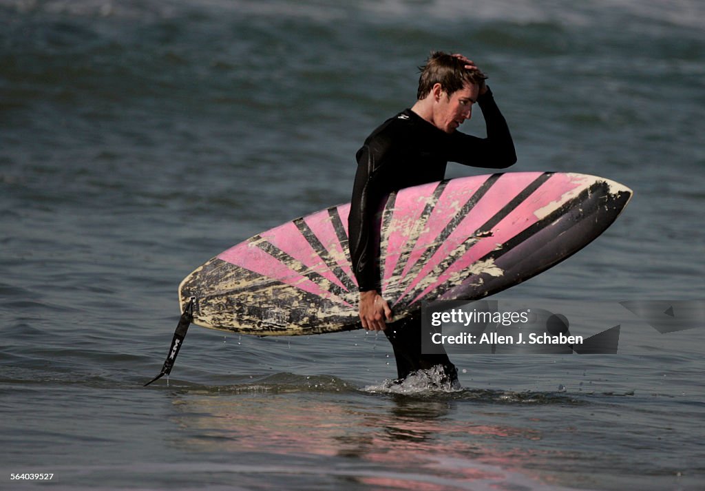Surfer Paul Vanderheiden, 26, of Hermosa Beach, exits the surf at 27th Street in Manhattan Beach, n
