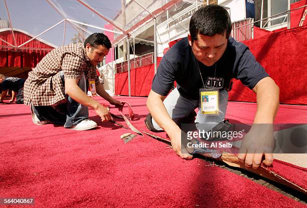On Wednesday Hugo Escobar, working for ATC american turf and event flooring, right and an unidentified workman, left lay the red carpet under the...