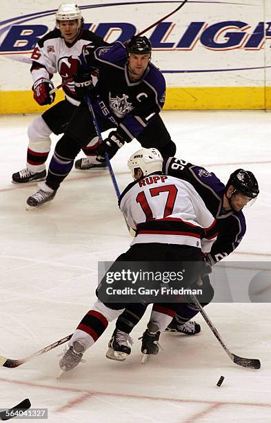 Marty Murray of the Los Angeles Kings tries to get by Mike Rupp of the New Jersey Devils during 2nd period action Monday, Nov. 27, 2006 at the...