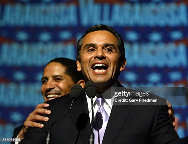 Antonio Villaragoisa gets a pat on the back by L.A. City Councilman Martin Ludlow , as Villaragoisa makes a mistake in quoting a speech by John...