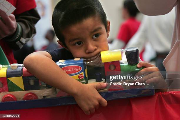 Johnny Guerrero clutches a toy train set he received for Christmas at the Union Rescue Mission's annual "Christmas Store" which provides more than...