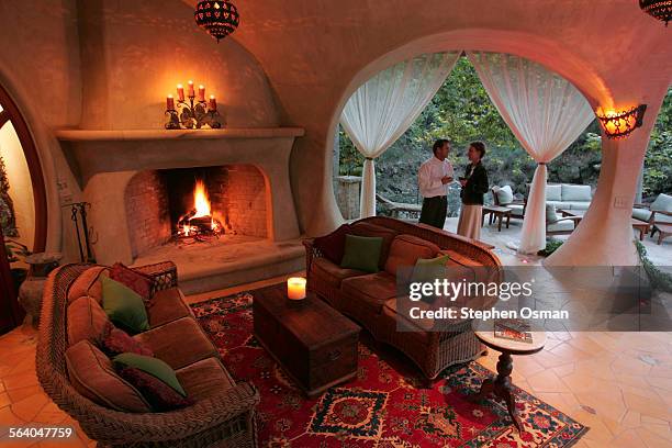 Mark and Julia on the back patio. Architect Mark Whitman and his wife Julia own a house built around a tree, enlarged from a 1930's cabin. The ground...