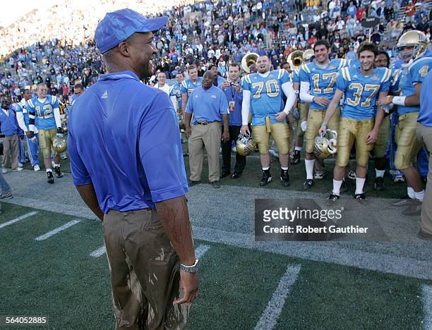 Bruins football coach Karl Dorrell stands soaked but satisfied along the sidelines after defeating the Northwestern Wildcats 5038at the Vitalis Sun...