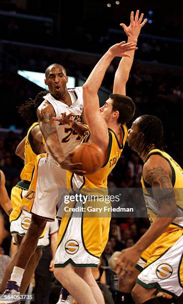 Laker Kobe Bryant passes off to a teammate as Seattle SuperSonics Nick Collison, center, defends along with Chris Wilcox, far right in the first...