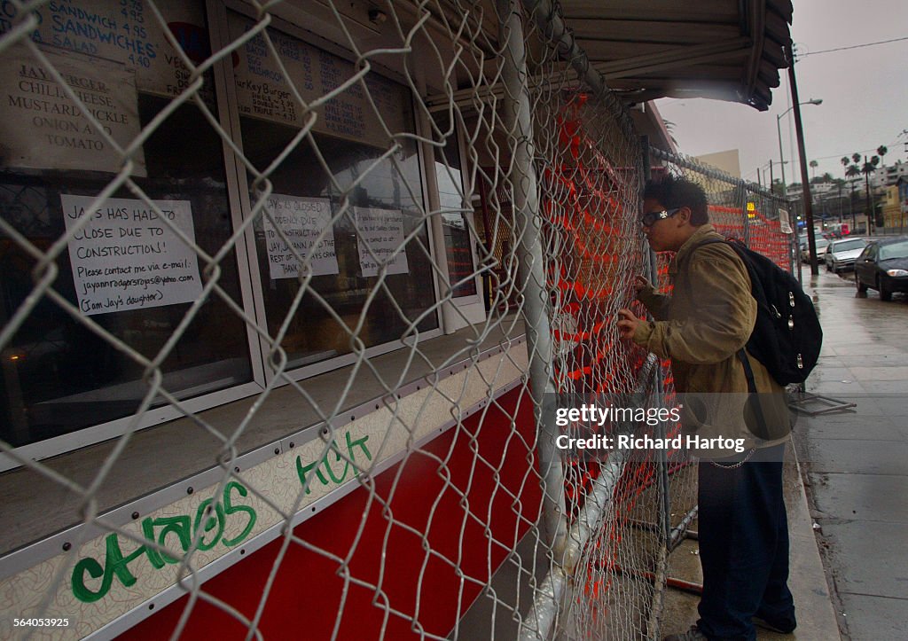 Twelveyearold Alex Garcia looks through a fence at the legendary Jay's Jayburger stand, Thursday