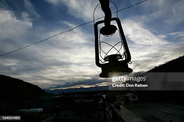   Kerosene lantern silhouetted against evening sky, hangs outside Cerro Gordo museum, a relict of days gone by. The former riproaring 1870s silver...