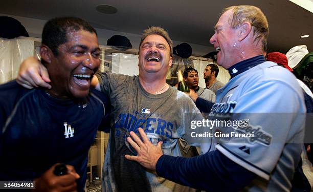 Dodger coaches Mariano Duncan,left, and Richard Donnelly,right, celebrate with Dodgers GM Ned Colletti celebrate after clinching the wildcard with a...