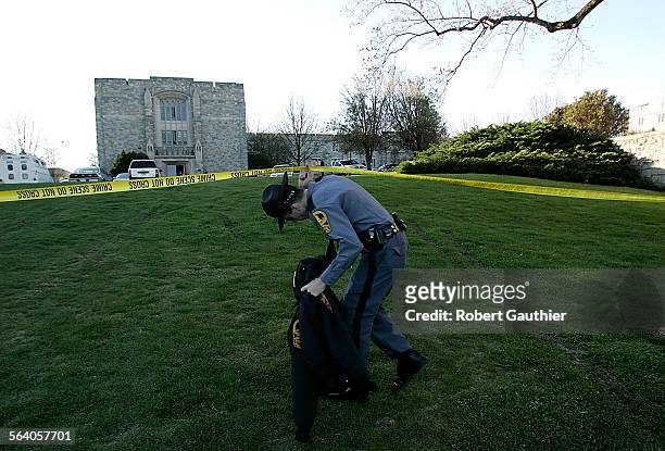 Virginia State Trooper ducks under crime scene tape surrounding Norris Hall, the scene of Monday's massacre at Virginia Tech University in...